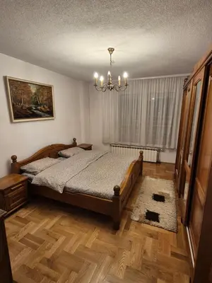 a bedroom with a bed and a chandelier at Apartment D&D in Krndija