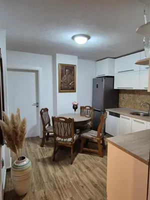 a kitchen with a table and chairs and a refrigerator at Apartment D&D in Krndija