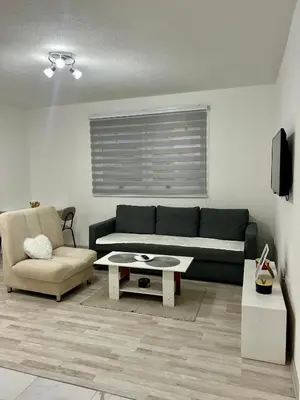 a living room with a couch and a chair at Apartman M