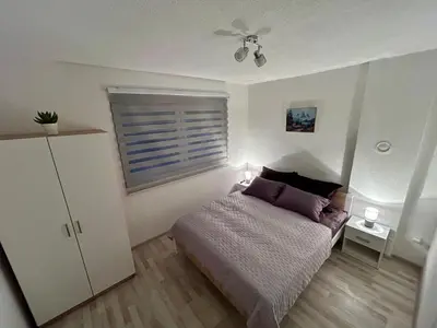 a bedroom with a bed and a ceiling fan at Apartman M