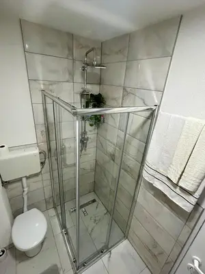 a bathroom with a shower and a toilet at Apartman M