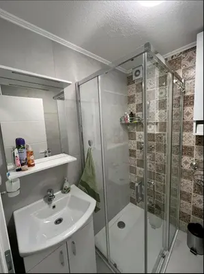 a bathroom with a glass shower and a sink at Apartman Ana in Banja Luka