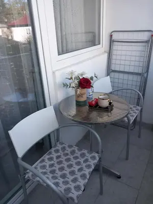 a table with two chairs and a table with flowers on it at Apartman Ana in Banja Luka