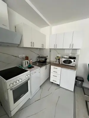 a white kitchen with a stove and a microwave at Apartman Ana in Banja Luka