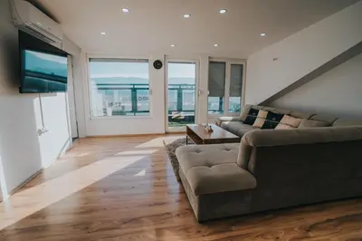 a living room with a couch and a tv at TheLuxPenthouseBugojno in Bugojno
