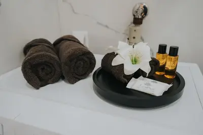 a bathroom counter with towels and complimentary perfume and cosmetics at TheLuxPenthouseBugojno in Bugojno