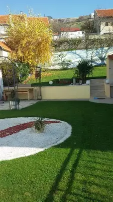 a garden with a grassy yard with a fountain at Apartment M in Livno