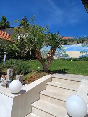 a staircase with two palm trees in a yard at Apartment M in Livno