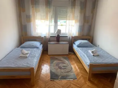 two beds in a room with a window at Apartment M in Livno