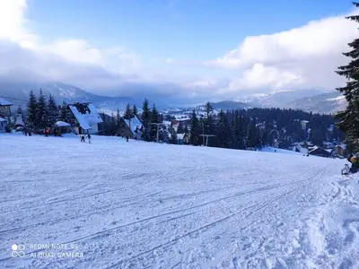 a snow covered slope with people skiing on a mountain at Vikend kuća Libertas in Šišava