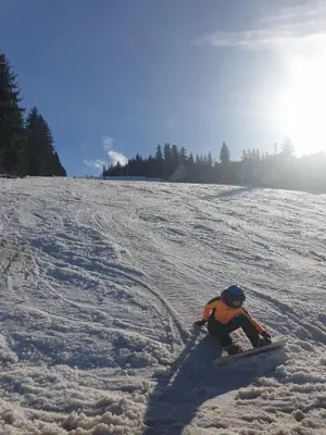a person riding a snowboard down a snow covered slope at Vikend kuća Libertas in Šišava