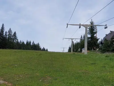 a grassy hill with a power pole in a field at Vikend kuća Libertas in Šišava