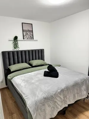 a bed with a black teddy bear sitting on it at Aurora Noir Retreat in Banja Luka