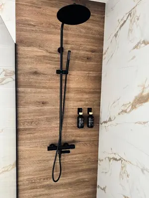 a shower in a bathroom with a wooden floor at Aurora Noir Retreat in Banja Luka
