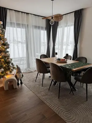 a dining room with a table and a christmas tree at Aurora Noir Retreat in Banja Luka