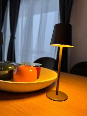 a table with a bowl of fruit and a lamp at Aurora Noir Retreat in Banja Luka