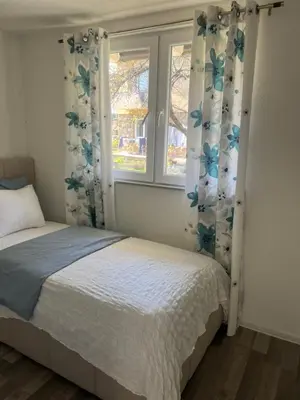 a bedroom with a bed and two windows at Vila jajcegrad in Jajce