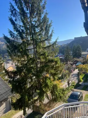 a large pine tree on the side of a balcony at Vila jajcegrad in Jajce