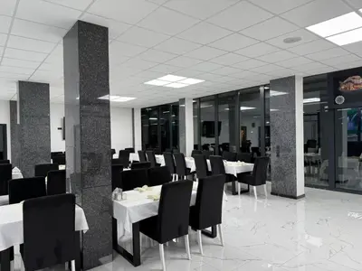 a dining room with white tables and black chairs at Motel i Restoran Krajina in Cazin