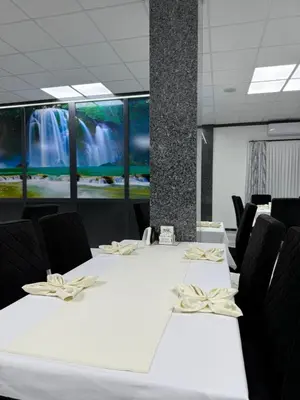 a meeting room with a table with chairs and a waterfall at Motel i Restoran Krajina in Cazin
