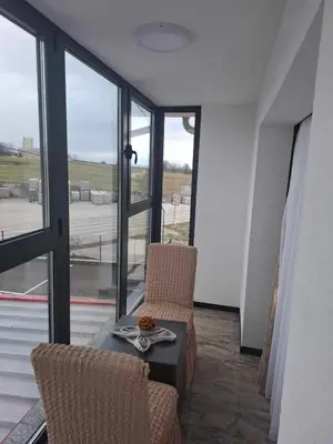 a room with a table and chairs and windows at Motel i Restoran Krajina in Cazin