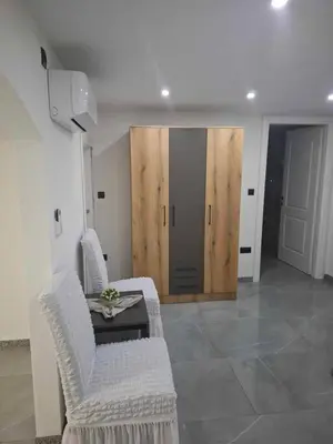 a living room with two chairs and a table and a door at Motel i Restoran Krajina in Cazin