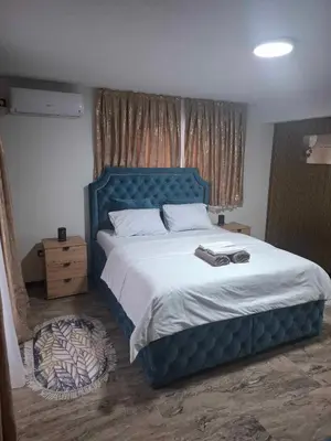 a bedroom with a large bed with a blue headboard at Motel i Restoran Krajina in Cazin