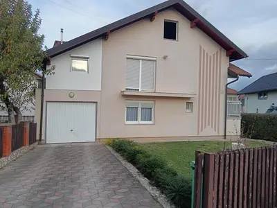 a house with a white garage and a brick driveway at Apartmani Srebrenik in Srebrenik