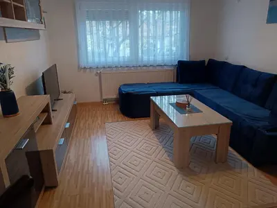 a living room with a blue couch and a coffee table at Apartmani Srebrenik in Srebrenik