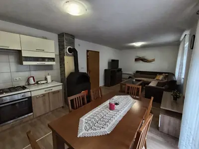 a kitchen and a living room with a table and chairs at Divan Vlašić in Šišava