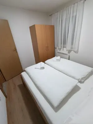 two beds in a room with white sheets at Divan Vlašić in Šišava