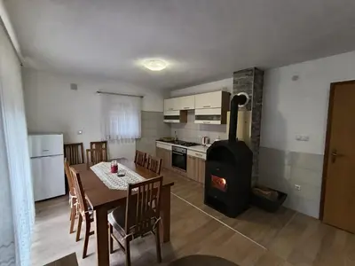 a kitchen and dining room with a table and a stove at Divan Vlašić in Šišava