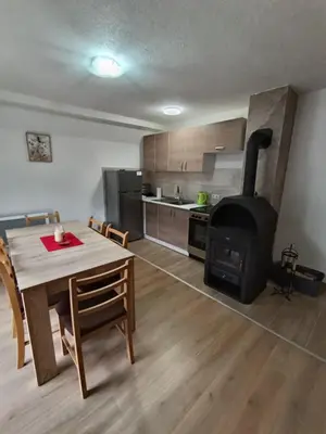 a kitchen and dining room with a table and a stove at Divan Vlašić in Šišava