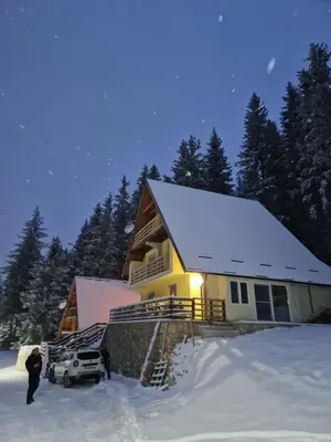 a house in the snow with a truck in front of it at Divan Vlašić in Šišava