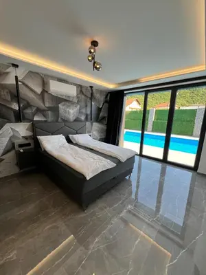 a bedroom with two beds and a wall of windows at villa M&B in Zbilje