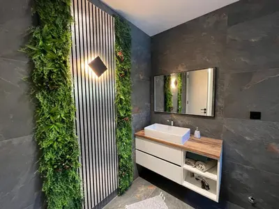 a bathroom with a green wall with a sink and a mirror at villa M&B in Zbilje