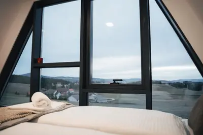 a bed in front of a window with a view at The Sky Hill - luxury chalet in Kupres