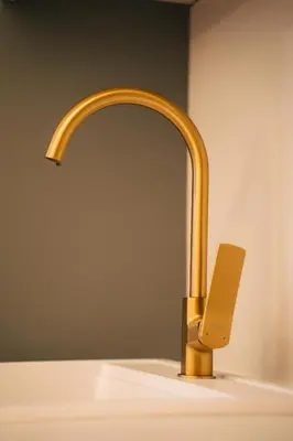 a bathroom sink with a gold faucet at The Sky Hill - luxury chalet in Kupres