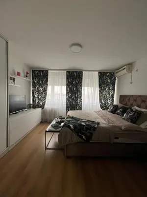 a bedroom with a large bed and a television at Chill In Apartman in Banja Luka