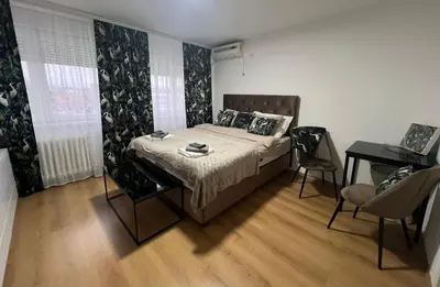 a bedroom with a bed and a table and chairs at Chill In Apartman in Banja Luka