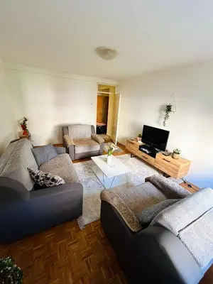 a living room with two couches and a tv at Apartman Buric