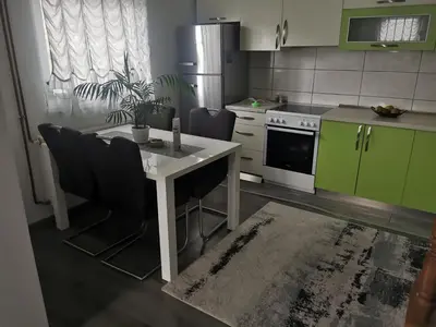 a kitchen with a white table and green cabinets at smještaj Visoko in Visoko