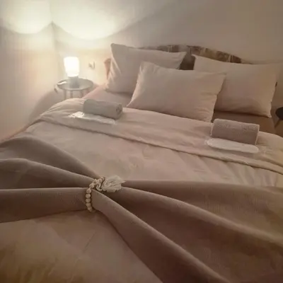 a large white bed with two towels on it at Livno Sympan in Livno