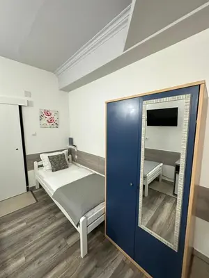 a small bedroom with a bed and a mirror at Banja Luka Arcadia in Banja Luka