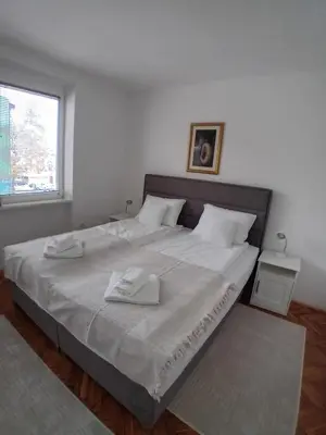 a bedroom with a large bed with two towels on it at Apartman BRKO in Bihać