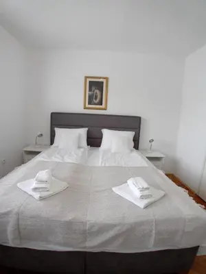 a bedroom with a large bed with two towels on it at Apartman BRKO in Bihać
