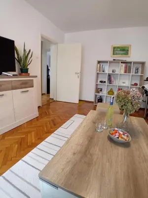 a living room with a table with a plate of food on it at Apartman BRKO in Bihać