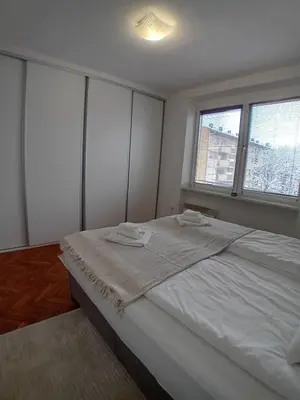 a bedroom with a white bed with two towels on it at Apartman BRKO in Bihać