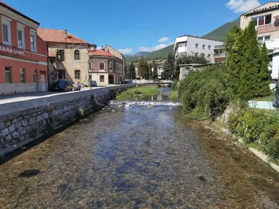 a river in the middle of a city with buildings at Apartman Školska in Travnik