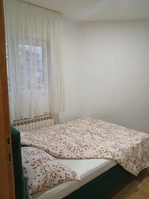 a bed in a room with a window at Apartman Školska in Travnik